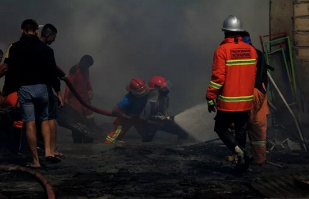 Petugas pemadam kebakaran bersama warga berusaha memadamkan api yang membakar gudang mebel di Kota Kupang, NTT,