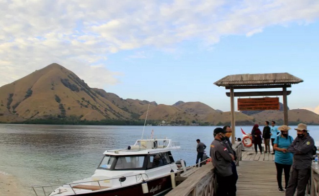 Petugas menggunakan masker berjaga di pintu masuk pintu masuk kawasan wisata Pulau Kelor di Taman Nasional Komodo, Manggarai Barat,NTT