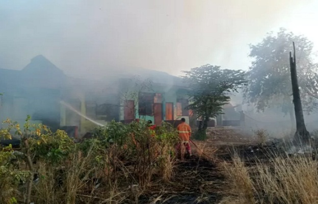 Petugas pemadam kebakaran berusaha memadamkan api yang menghanguskan belasan kamar kos di desa Penfui Timur.